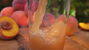 Şeftali suyu şeftali bahçesinin arka planındaki bir sürahiye dökülür.