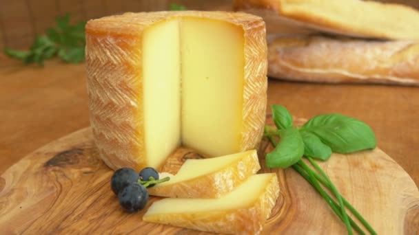 Колесо жесткого возраста из французского сыра, разрезанного на ломтики на деревянной доске — стоковое видео