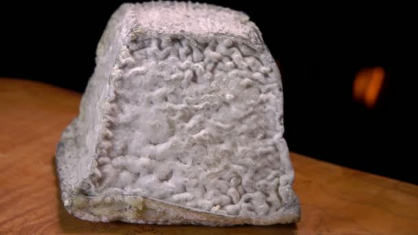 Deliciosa pirámide de queso Valencay con moho gris sobre un fondo de una chimenea — Vídeo de stock