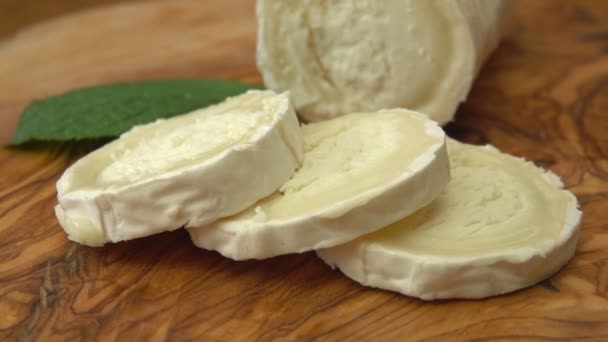 Rebanada de queso de cabra Sainte Maure de Touraine se toma de una tabla de madera — Vídeo de stock