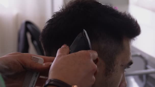 Friseur macht einem männlichen dunkelhaarigen Kunden eine männliche Maschinenfrisur — Stockvideo