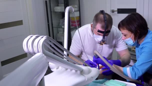 Un dentista haciendo limpieza dental profesional en los dientes de un paciente — Vídeo de stock