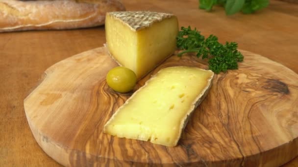 Pedazo de queso de cabra envejecido duro puesto en una tabla de madera — Vídeo de stock
