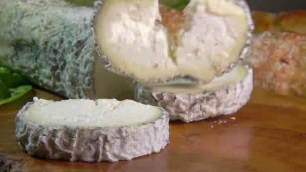 Un pezzo di formaggio di capra Sainte Maure de Touraine con una cannuccia cade su una tavola — Video Stock