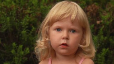 Güzel sarışın kız elini sallıyor ve gökyüzüne bakıyor.