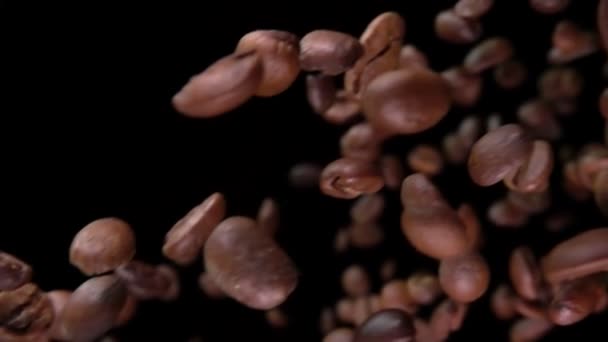 Primer plano de granos de café arabica tostados volando en diagonal sobre fondo negro — Vídeo de stock
