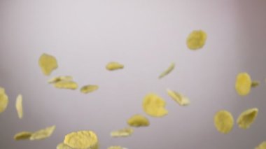 Mısır gevreği beyaz arka planda uçuyor ve dönüyor.