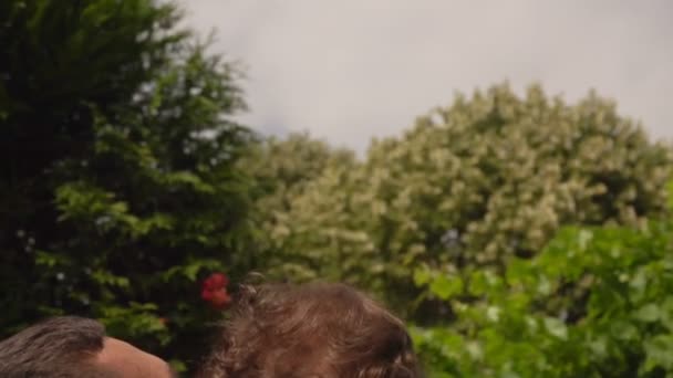 Gelukkig vader kotst een vrolijke kleine jongen buiten — Stockvideo