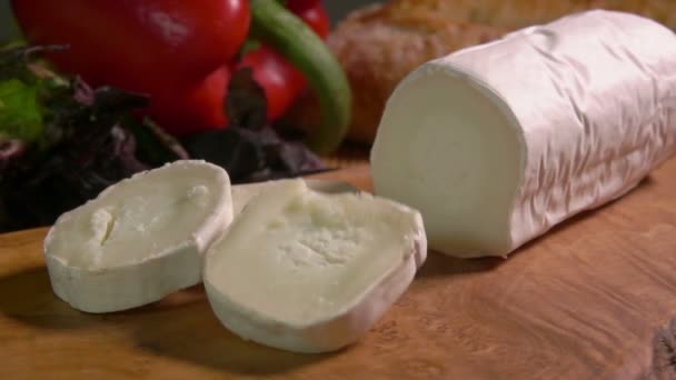 Ένα μεγάλο στρογγυλό κομμάτι κατσικίσιο τυρί Sainte Maure de Touraine πέφτει σε μια σανίδα — Αρχείο Βίντεο