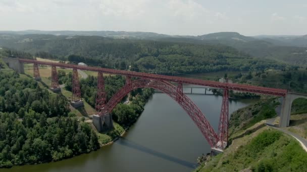 Panorama aéreo tiroteio da bela ponte ferroviária vermelha sobre o rio — Vídeo de Stock