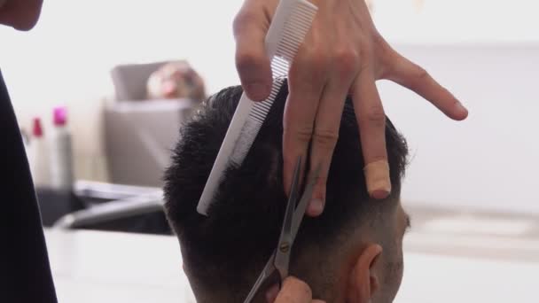 Крупный план парикмахерских рук, делающих мужскую стрижку ножницами — стоковое видео