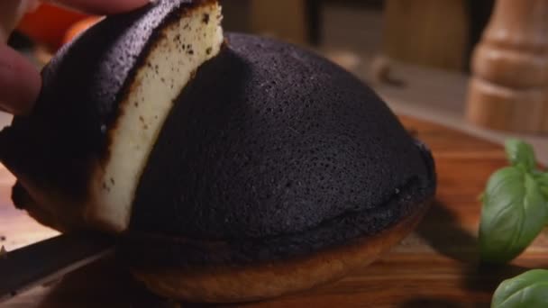 Mano toma un pedazo de Tourteaux Jahan pastel de requesón negro con un cuchillo — Vídeo de stock