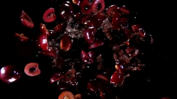 Галлі смачних темно-червоних вишень підстрибують з бризками соку — стокове відео
