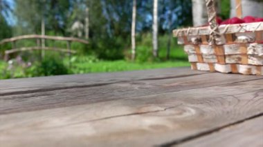 Büyük, sulu, iştah açıcı ahududu dolu huş ağacı sepeti masaya düşüyor.