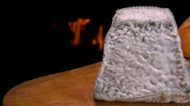 Fransız ekmeğinin yanındaki ahşap tahtanın üzerinde Valencay peyniri panoraması.