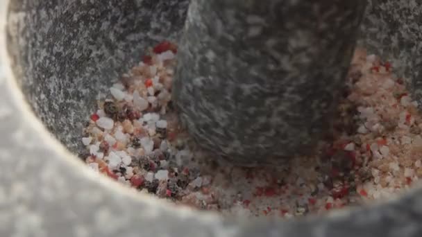 Pestolo sta macinando un mix di spezie, peperoni e sale marino nel mortaio di pietra — Video Stock