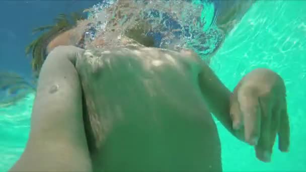 Мальчик делает подводное селфи — стоковое видео