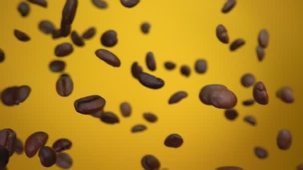 Chicchi di caffè torrefatto stanno volando diagonalmente sullo sfondo giallo — Video Stock