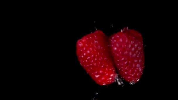 Dvě velké šťavnaté chutné maliny se střetávají s cákancemi vody — Stock video