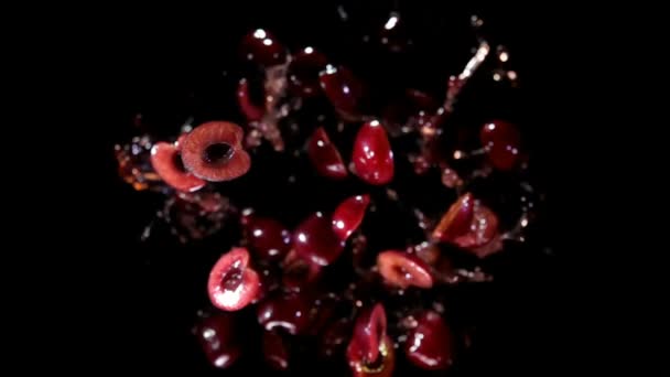Des moitiés de cerises délicieuses rebondissent et tournent avec des éclaboussures de jus — Video