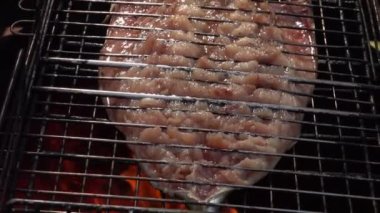 Barbekü ızgarasına yerleştirilmiş lezzetli beyaz balığın üst görüntüsü.