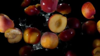 Taze olgun şeftalinin yarısı su damlalarıyla zıplıyor. 