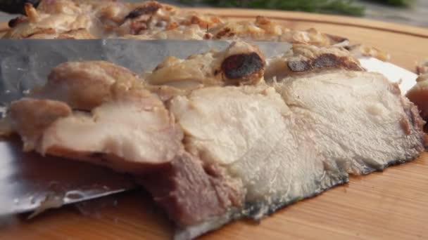Primer plano del filete de pescado blanco a la parrilla cortado con un cuchillo en la tabla de madera — Vídeos de Stock