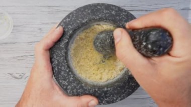 El, havanda deniz tuzu, limon ve esmer şeker öğütüyor.