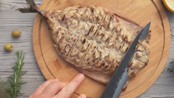 Vista superior do delicioso filé de peixe branco grelhado suculento cortado com uma faca — Vídeo de Stock