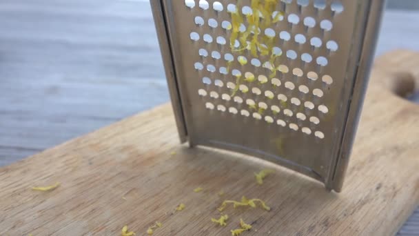 Close-up de ralar limão no ralador de metal nas raspas de limão — Vídeo de Stock