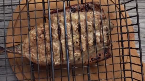 Barbeque grill grid with a delicious white fish put on the board and opened — Stock Video