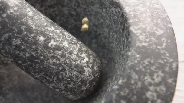 Super-Nahaufnahme grüner Pfefferkörner, die in den grauen Steinmörtel fallen — Stockvideo