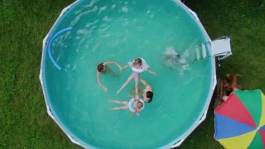 Yüzen ve eğlenen bir grup çocukla havuzda havadan çekim yapmak.