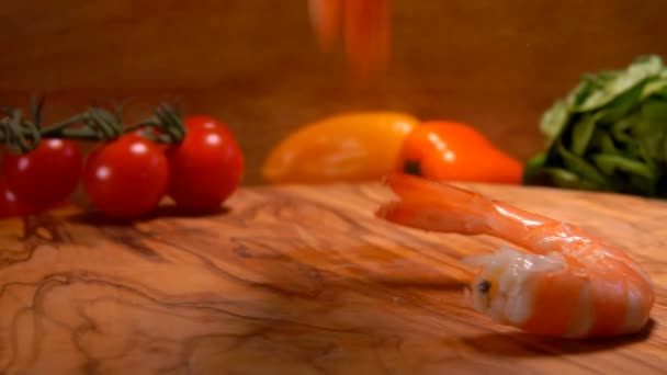 Super close-up van heerlijke gepelde garnalen die op het houten bord vallen — Stockvideo