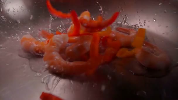 Close-up van heerlijke gepelde garnalen die op de verwarmde olijfolie vallen — Stockvideo