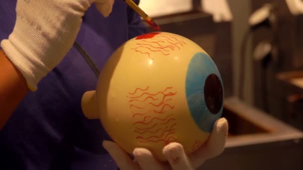 Artista de confeitaria está pintando um olho de chocolate branco para a festa de Halloween — Vídeo de Stock