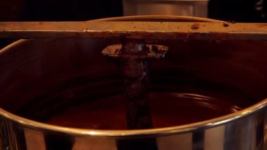 Lezzetli eritilmiş siyah çikolata büyük şekerleme karıştırıcısına karıştırılır.