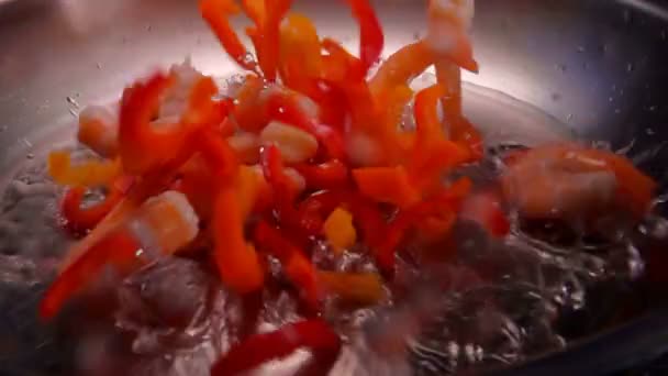Högen med läckra skalade räkor och paprika faller på den uppvärmda olivolja — Stockvideo