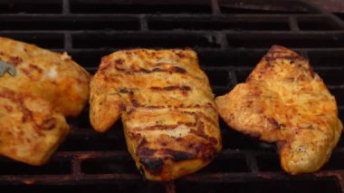 Mutfak maşaları ızgaradan ızgara tavuk filetosu alıyor.