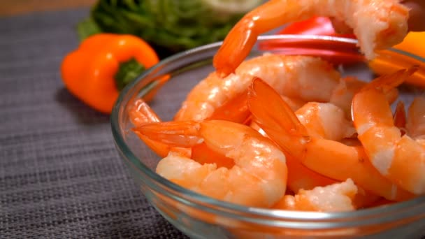 Close-up of a hand laying a prepared shrimp in a glass bowl — Stock Video