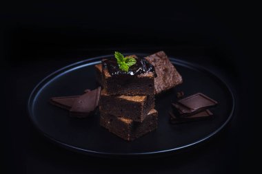 Ev yapımı koyu çikolata kek badem dilimleri ve nane ile Tepesi kopya alanı ile ahşap masa üzerinde yığılmış. Lezzetli acı tatlı ve şekerleme. Brownie bir çikolatalı kek türüdür.