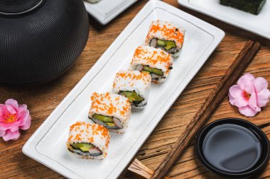 Beyaz tabakta servis edilen suşi ruloları, Japon yemekleri.  