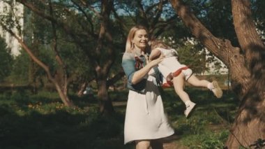 Eğleniyor ve parkta oynarken küçük kızıyla birlikte beyaz annelerin