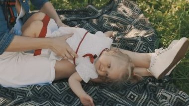 Anne ve kızı açık çim üzerinde yalan. Mutluluk annelik ve çocukluk