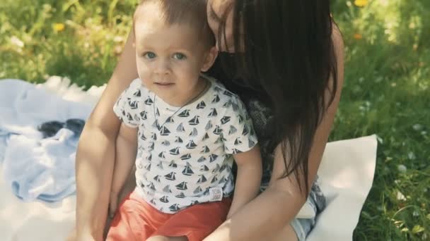 Feliz madre sonriente con hijo bebé en el picnic. Concepto de familia feliz — Vídeos de Stock