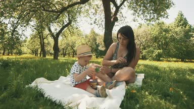 Piknik üzerinde bebek oğluyla mutlu gülümseyen anne. Mutlu aile kavramı