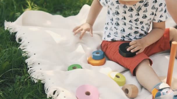 Ładny mały chłopiec bawi się zabawkami na piknik. Szczęśliwa rodzina koncepcja — Wideo stockowe