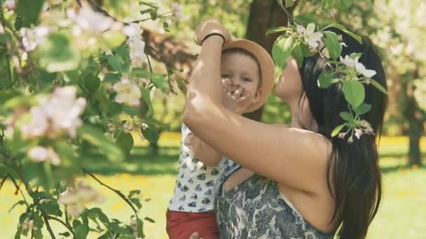 Jonge moeder met haar schattige kleine jongen buiten spelen met liefde — Stockvideo