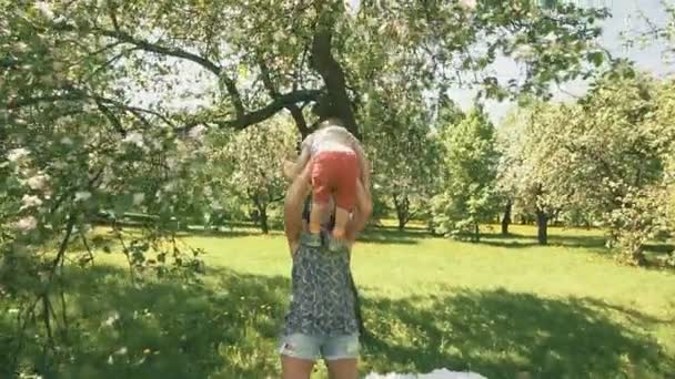 Mladá matka s její rozkošný dvouletý chlapec hraje venku s láskou — Stock video
