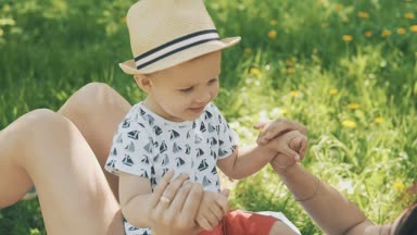 Mutlu genç anne sevimli oğlu Park'ta ağacın altında battaniyeyle oynuyor